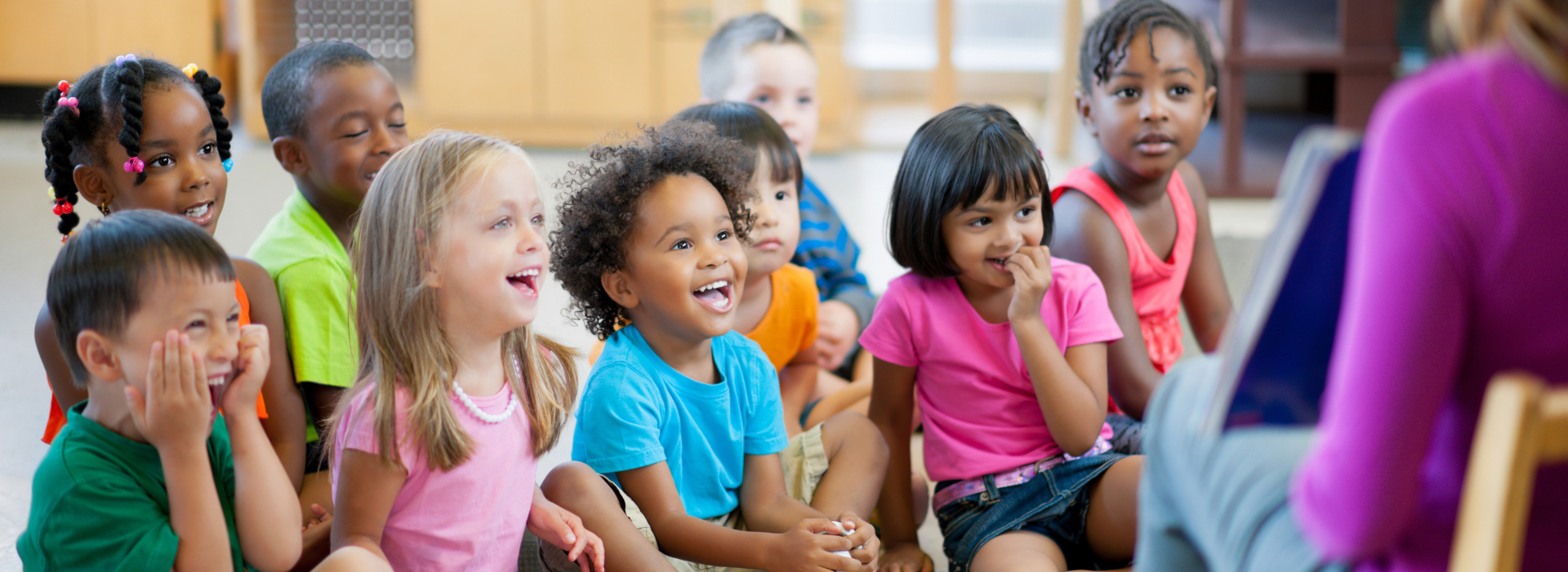 Un groupe d’enfants écoute l’éducatrice